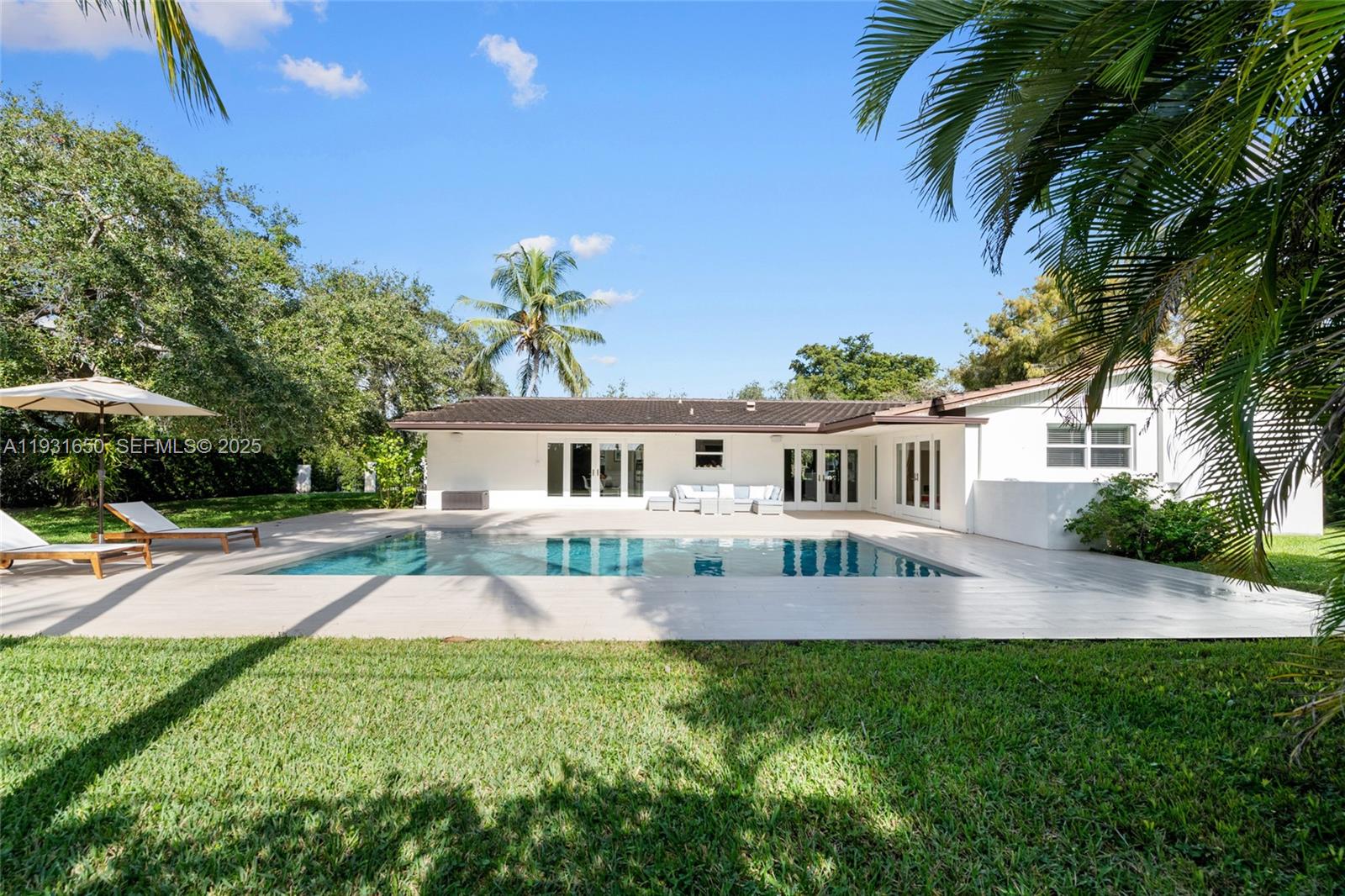 7360 Southwest 115th Street Pinecrest, FL 33156 - Photo 42 of 49 a front view of a house with a garden