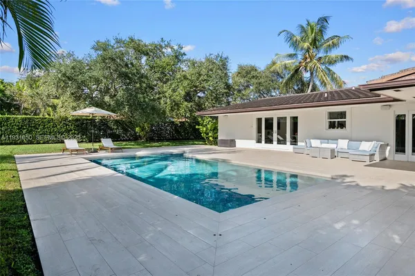 a backyard of a house with plants and large trees