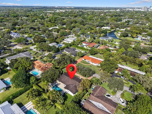 an aerial view of a house with a yard and large trees