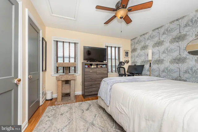 a spacious bedroom with a bed and a flat tv screen