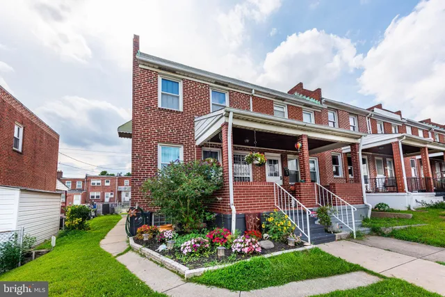 a front view of a house with a yard and potted plants