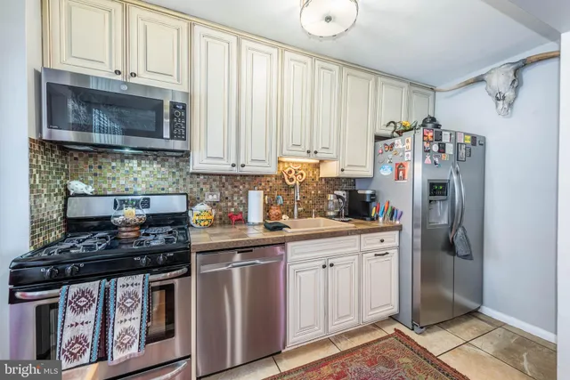 a kitchen with stainless steel appliances a refrigerator a sink and cabinets