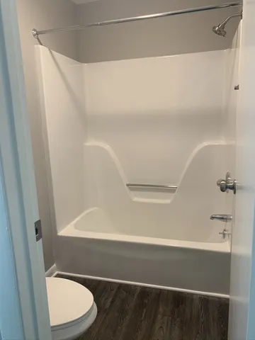 a bathroom with a white bathtub and a toilet