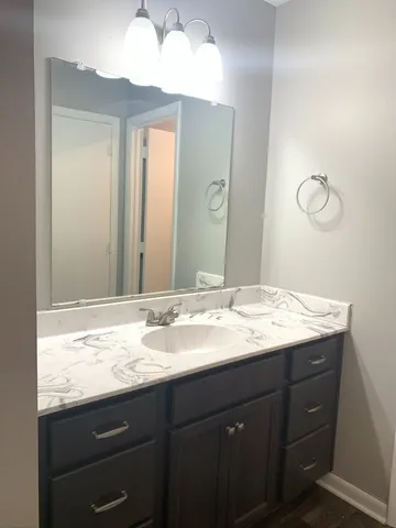 a bathroom with a granite countertop sink and a mirror