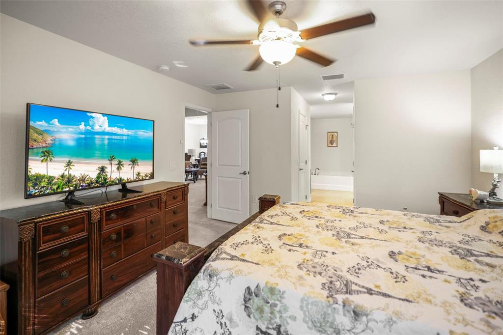 190 Rusk Circle Spring Hill, FL 34606 - Photo 17 of 35 a bedroom with a large bed and a flat tv screen on dresser