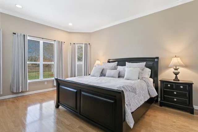 a bedroom with a bed with dresser and mirror