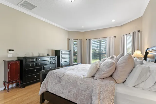 a bedroom with a bed and a lamp on dresser