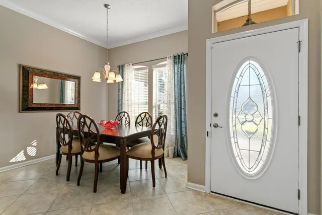 a dining room with furniture a chandelier and wooden floor