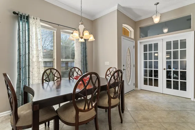 a dining room with furniture a chandelier and window