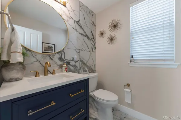 a bathroom with a granite countertop sink a toilet and a mirror