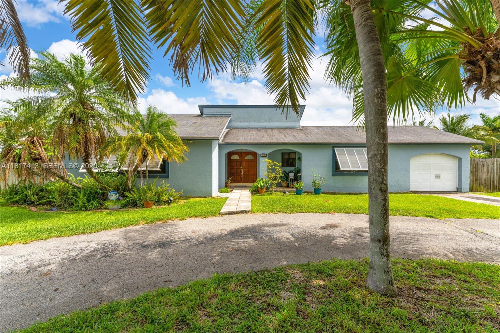 16040 Southwest 287th Street Homestead, FL 33033 - Photo 1 of 48 a front view of a house with garden and porch