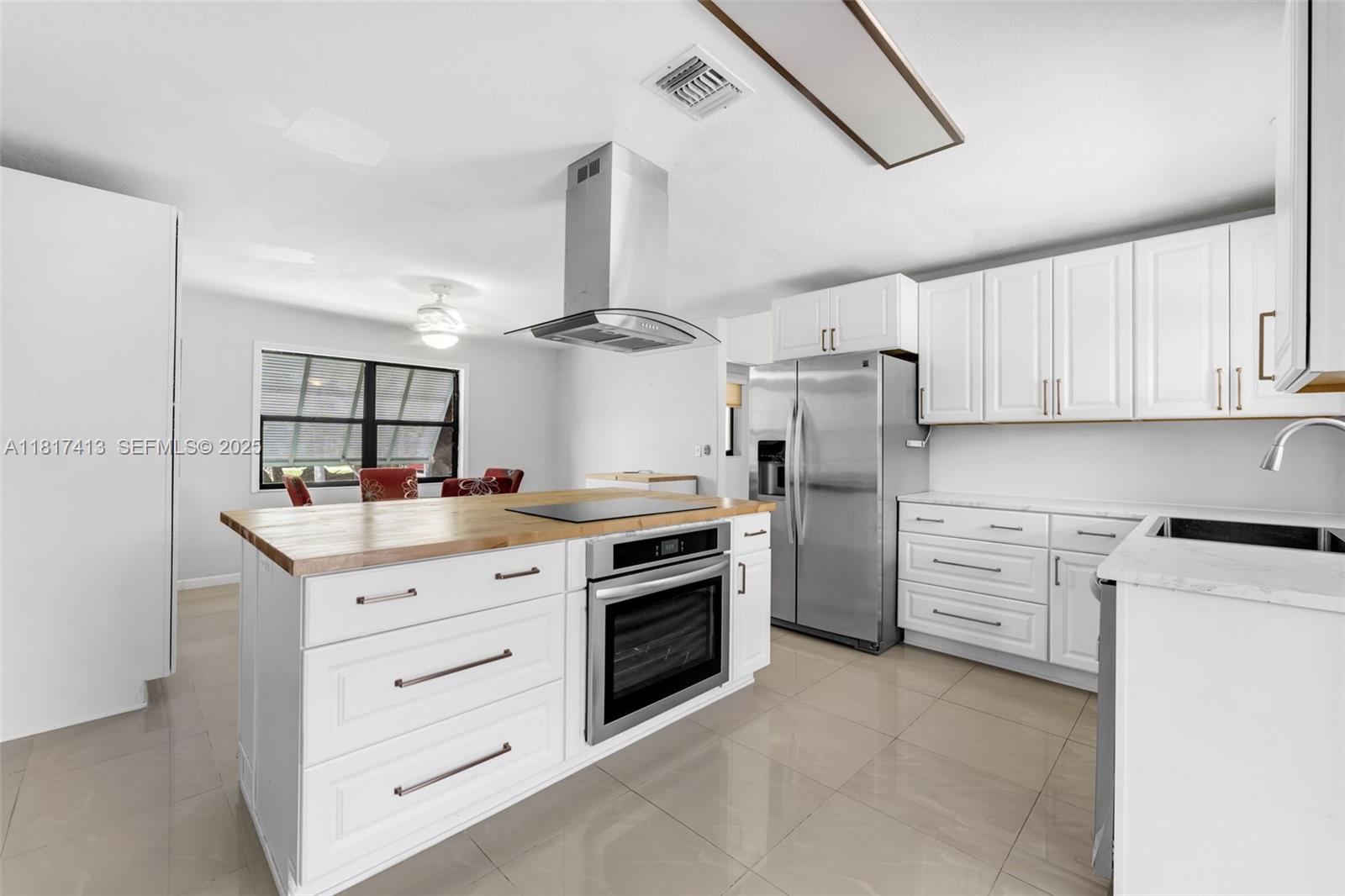 16040 Southwest 287th Street Homestead, FL 33033 - Photo 10 of 48 a kitchen with white cabinets and stainless steel appliances