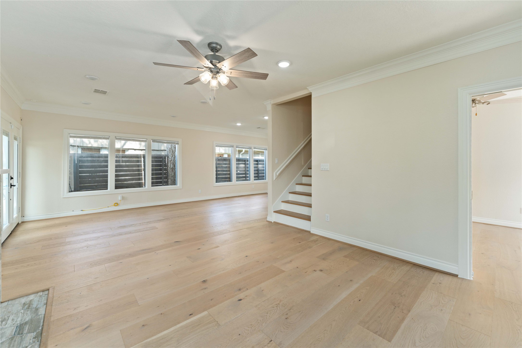 2631 Persa Street Houston, TX 77098 - Photo 11 of 25 an empty room with wooden floor fan and windows