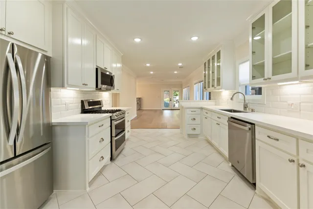 a kitchen with white cabinets and stainless steel appliances