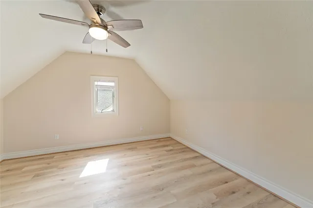 an empty room with a window and ceiling fan