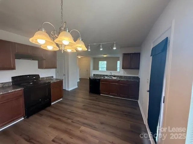 a kitchen with granite countertop white cabinets and black appliances