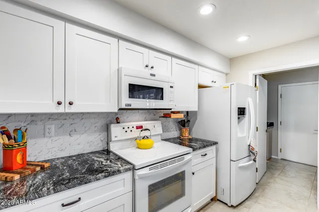 a kitchen with stainless steel appliances granite countertop a sink dishwasher stove and refrigerator