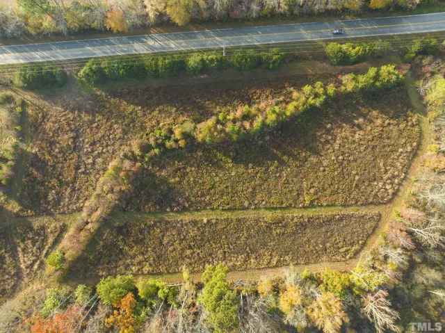 an aerial view of residential houses with outdoor space and lake view
