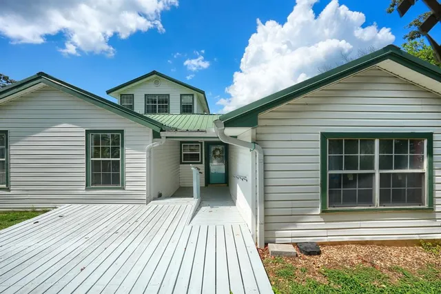 a living room with furniture a fireplace and a dining table with wooden floor
