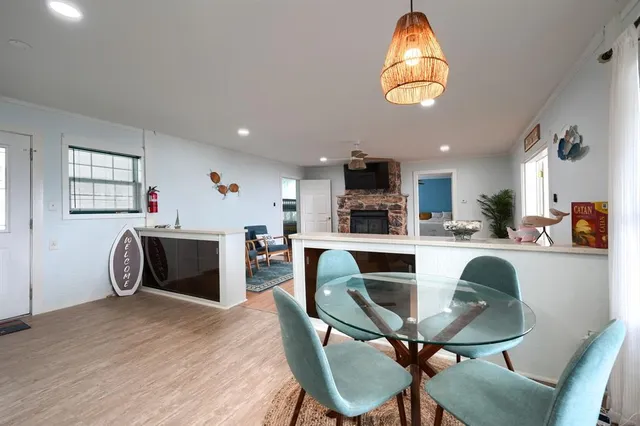 a kitchen with stainless steel appliances granite countertop a table chairs and a wooden floor