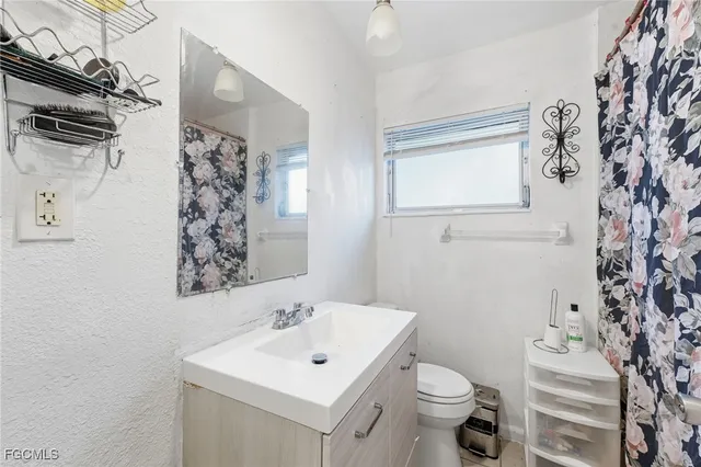 a bathroom with a toilet sink and mirror