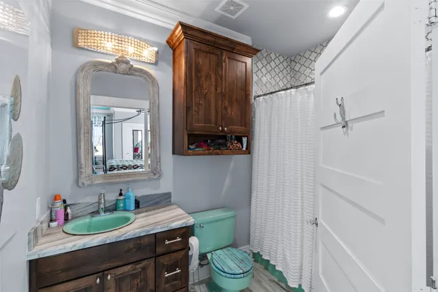 a bathroom with a granite countertop sink toilet and a mirror
