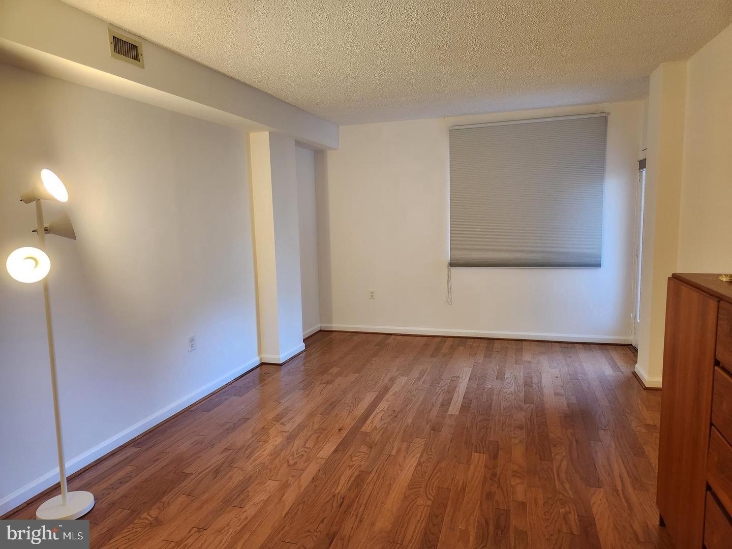 2725 Connecticut Avenue Northwest, Unit 406 Washington, DC 20008 - Photo 13 of 24 a view of an empty room with wooden floor and a window