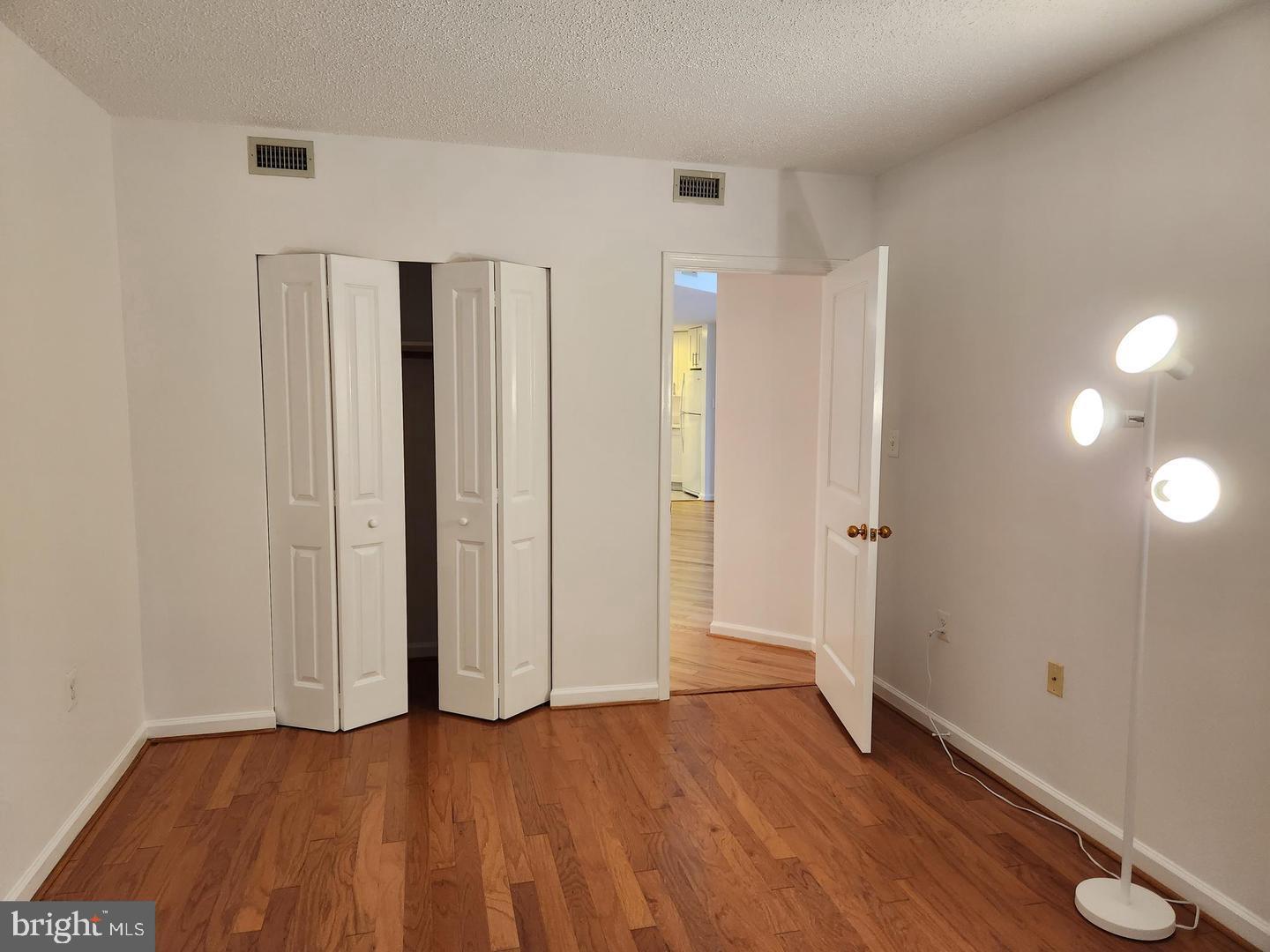 2725 Connecticut Avenue Northwest, Unit 406 Washington, DC 20008 - Photo 21 of 24 an empty room with wooden floor and windows