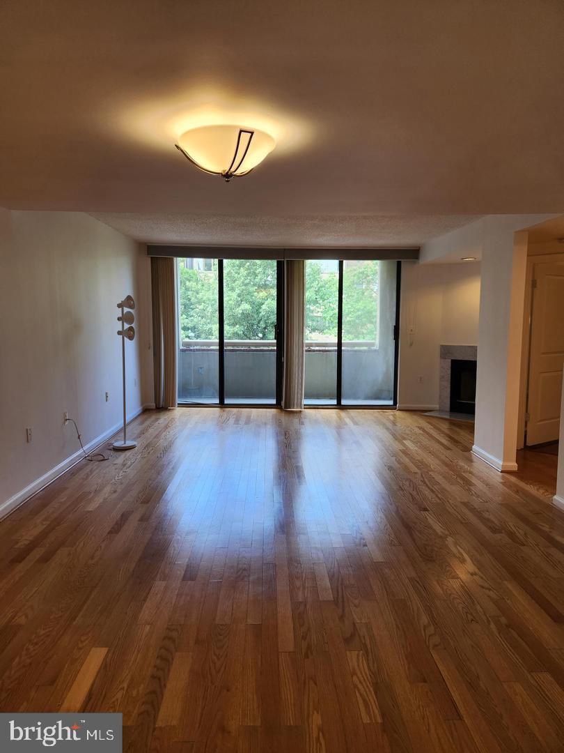 2725 Connecticut Avenue Northwest, Unit 406 Washington, DC 20008 - Photo 4 of 24 an empty room with wooden floor and windows