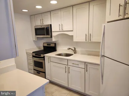 a kitchen with white cabinets and white stainless steel appliances