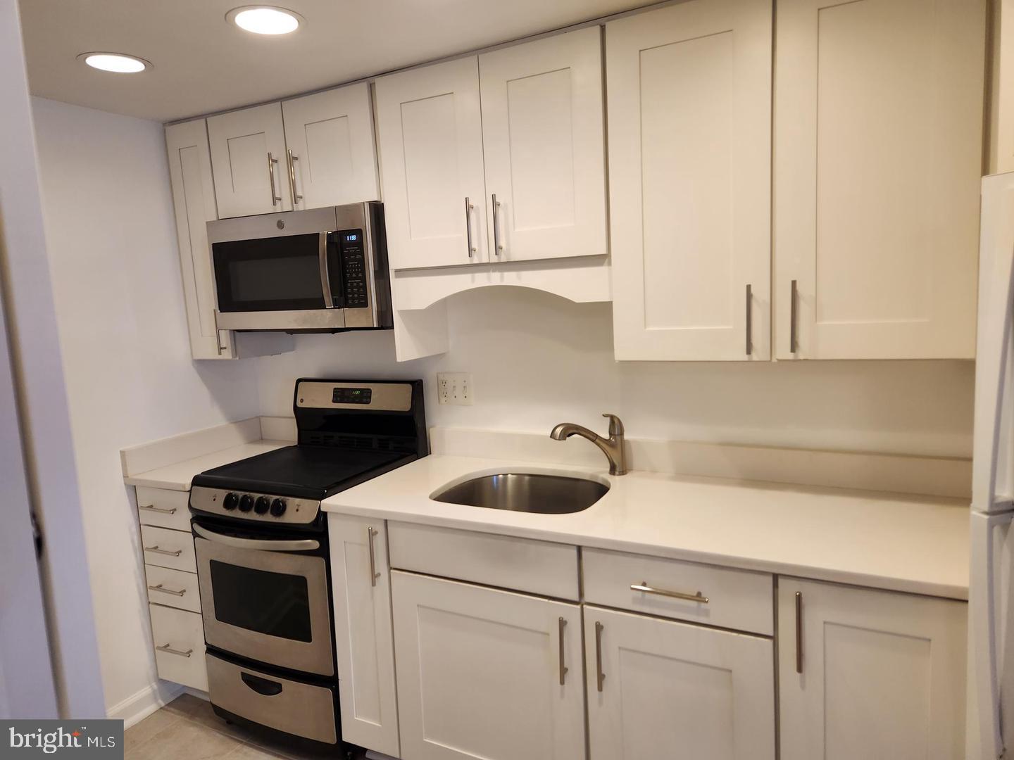 2725 Connecticut Avenue Northwest, Unit 406 Washington, DC 20008 - Photo 9 of 24 a kitchen with appliances a sink and cabinets