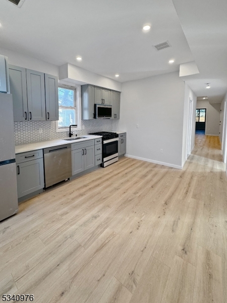 445 Grove Street, Unit 2 Irvington, NJ 07111 - Photo 11 of 11 a large kitchen with granite countertop a large counter top stainless steel appliances and cabinets