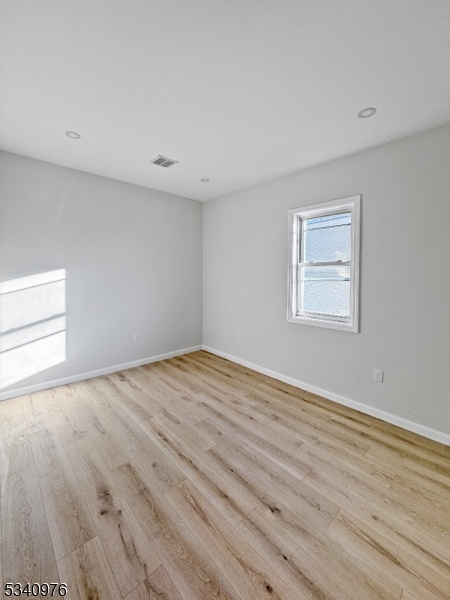 445 Grove Street, Unit 2 Irvington, NJ 07111 - Photo 7 of 11 a view of empty room with wooden floor and fan