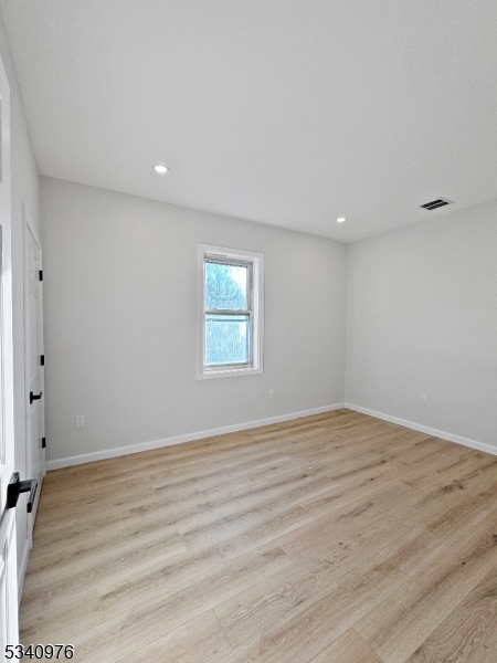 445 Grove Street, Unit 2 Irvington, NJ 07111 - Photo 9 of 11 a view of an empty room with wooden floor and a window