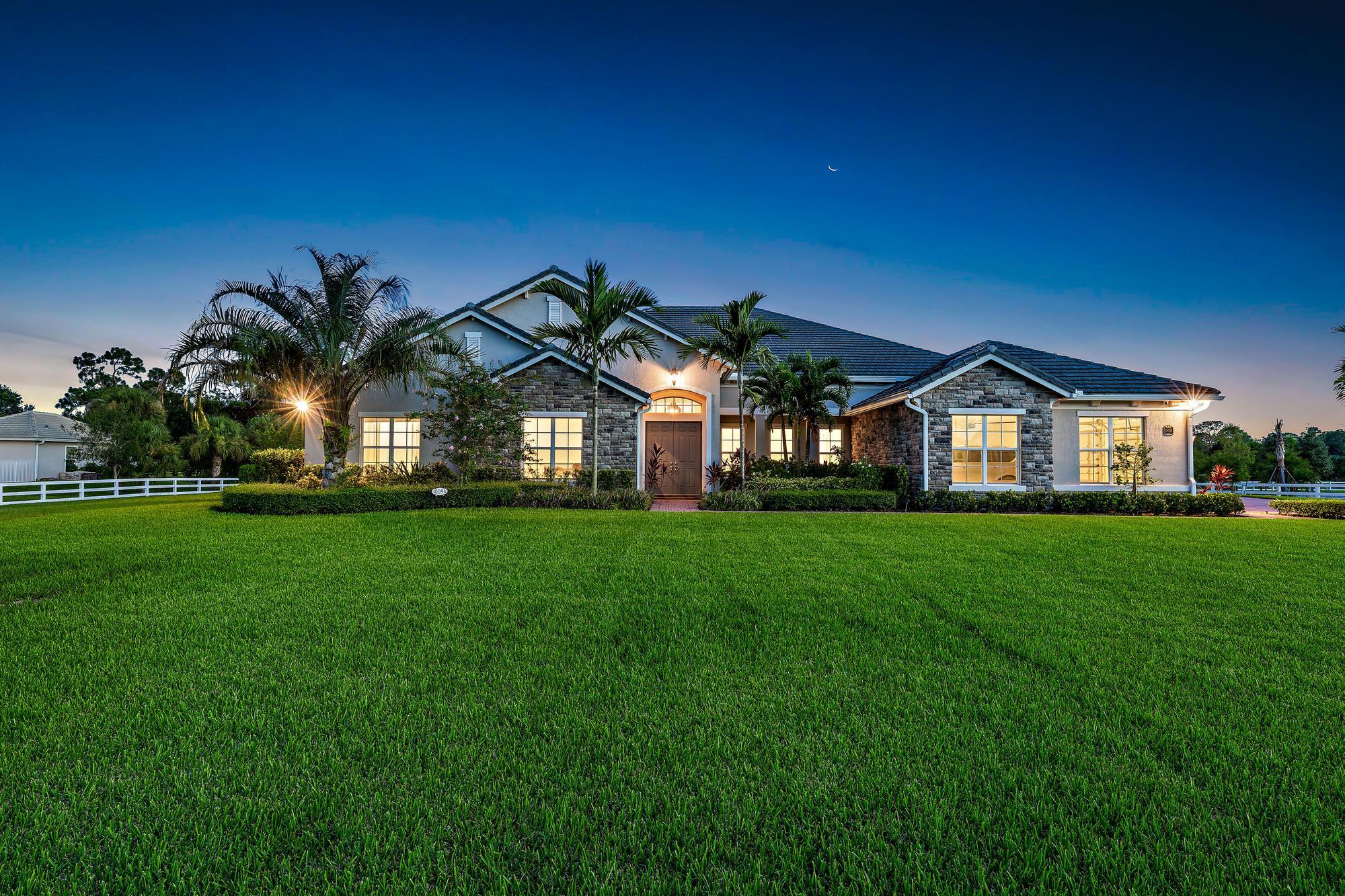 10096 Calabrese Trail Jupiter, FL 33478 - Photo 1 of 58 a view of a green field in front of a house