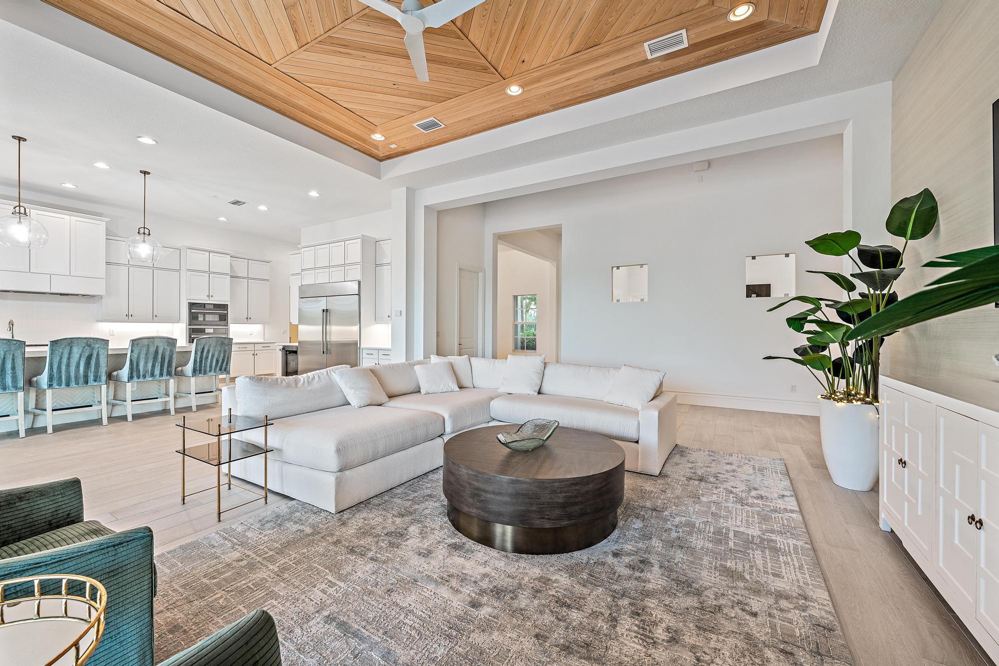 10096 Calabrese Trail Jupiter, FL 33478 - Photo 19 of 58 a living room with furniture a chandelier and a potted plant