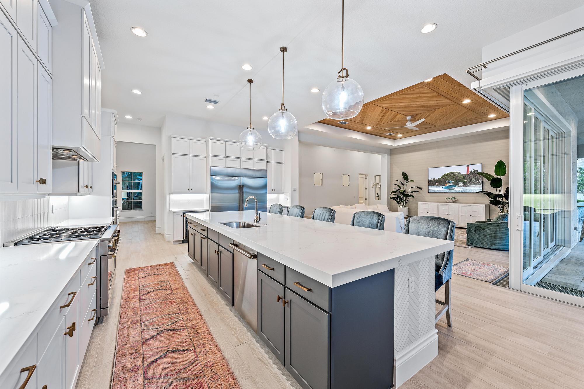 10096 Calabrese Trail Jupiter, FL 33478 - Photo 25 of 58 a large kitchen with kitchen island a stove a sink a center island and a stove top oven