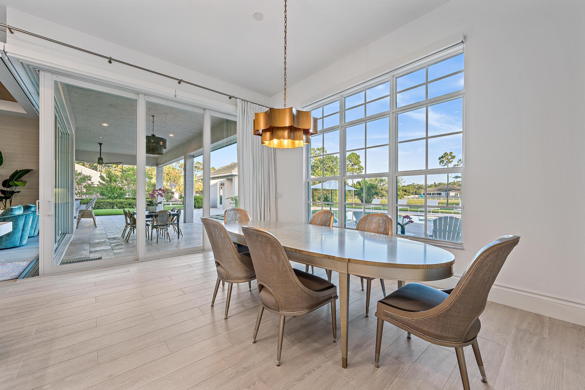 10096 Calabrese Trail Jupiter, FL 33478 - Photo 27 of 58 a dining room with furniture a chandelier and wooden floor