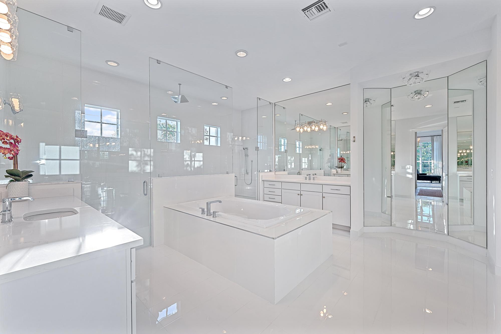 10096 Calabrese Trail Jupiter, FL 33478 - Photo 34 of 58 a bathroom with a sink a tub and a large mirror