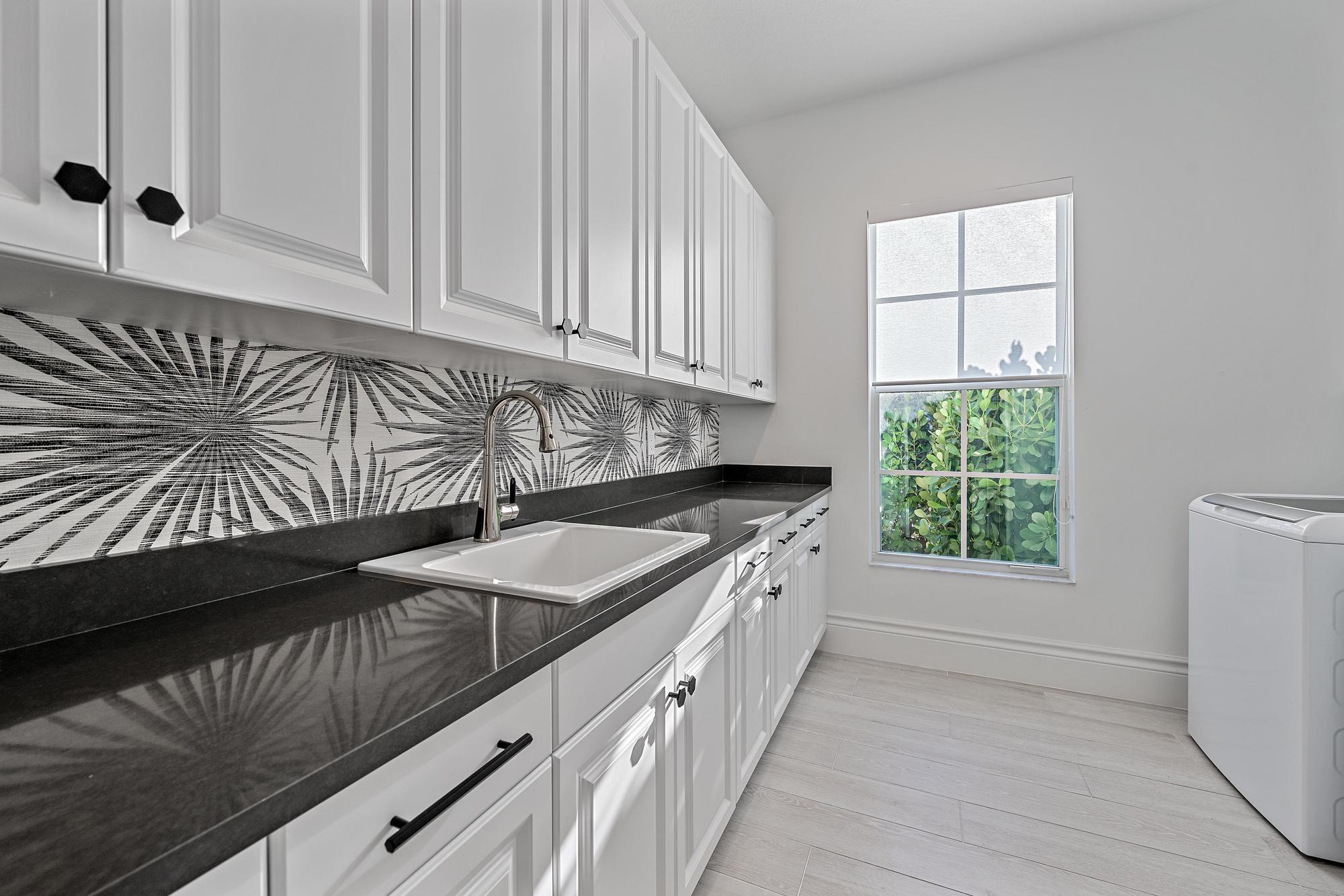 10096 Calabrese Trail Jupiter, FL 33478 - Photo 38 of 58 a kitchen with granite countertop a sink a stove and cabinets