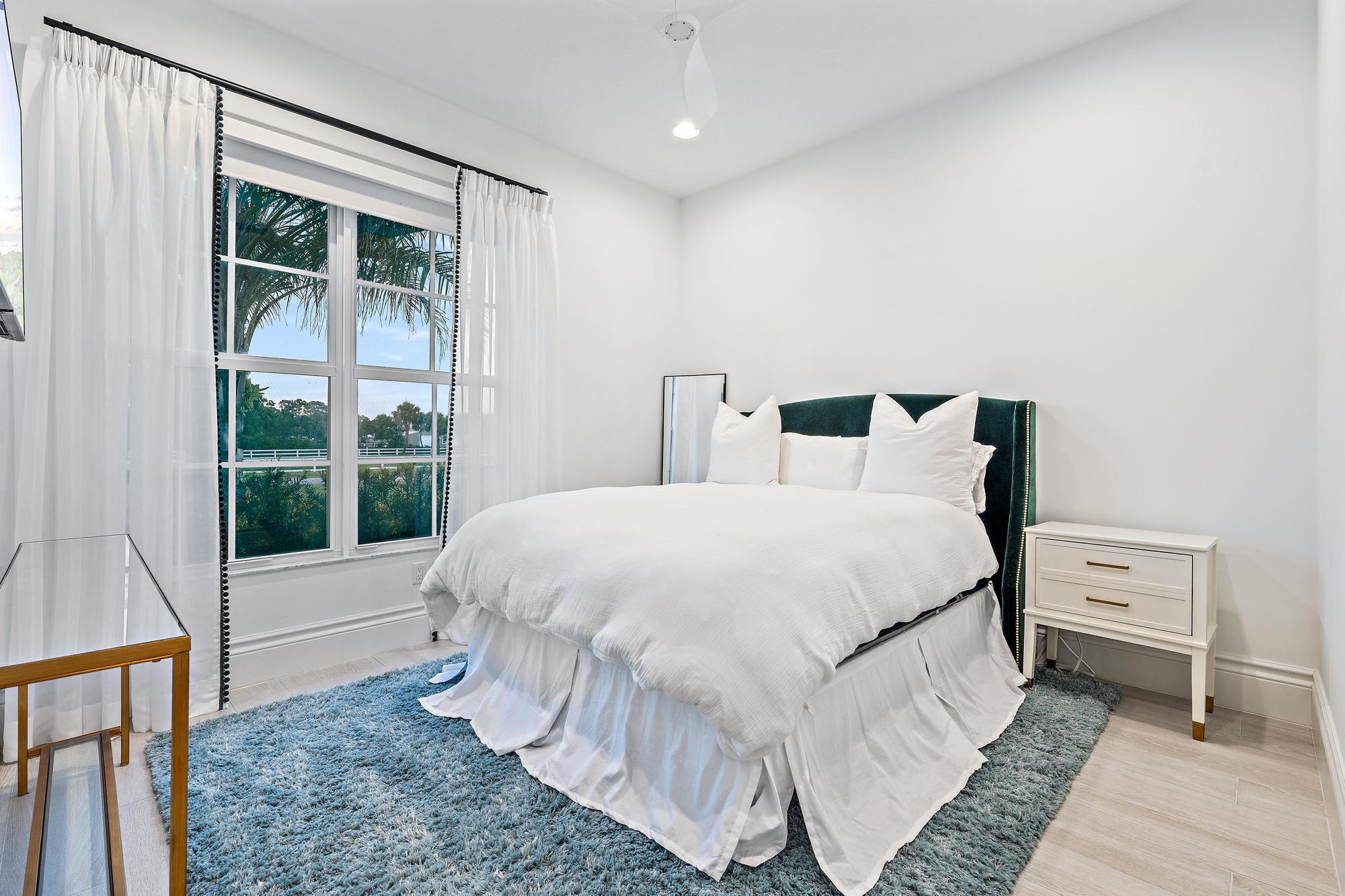 10096 Calabrese Trail Jupiter, FL 33478 - Photo 46 of 58 a bedroom with a bed and a large window