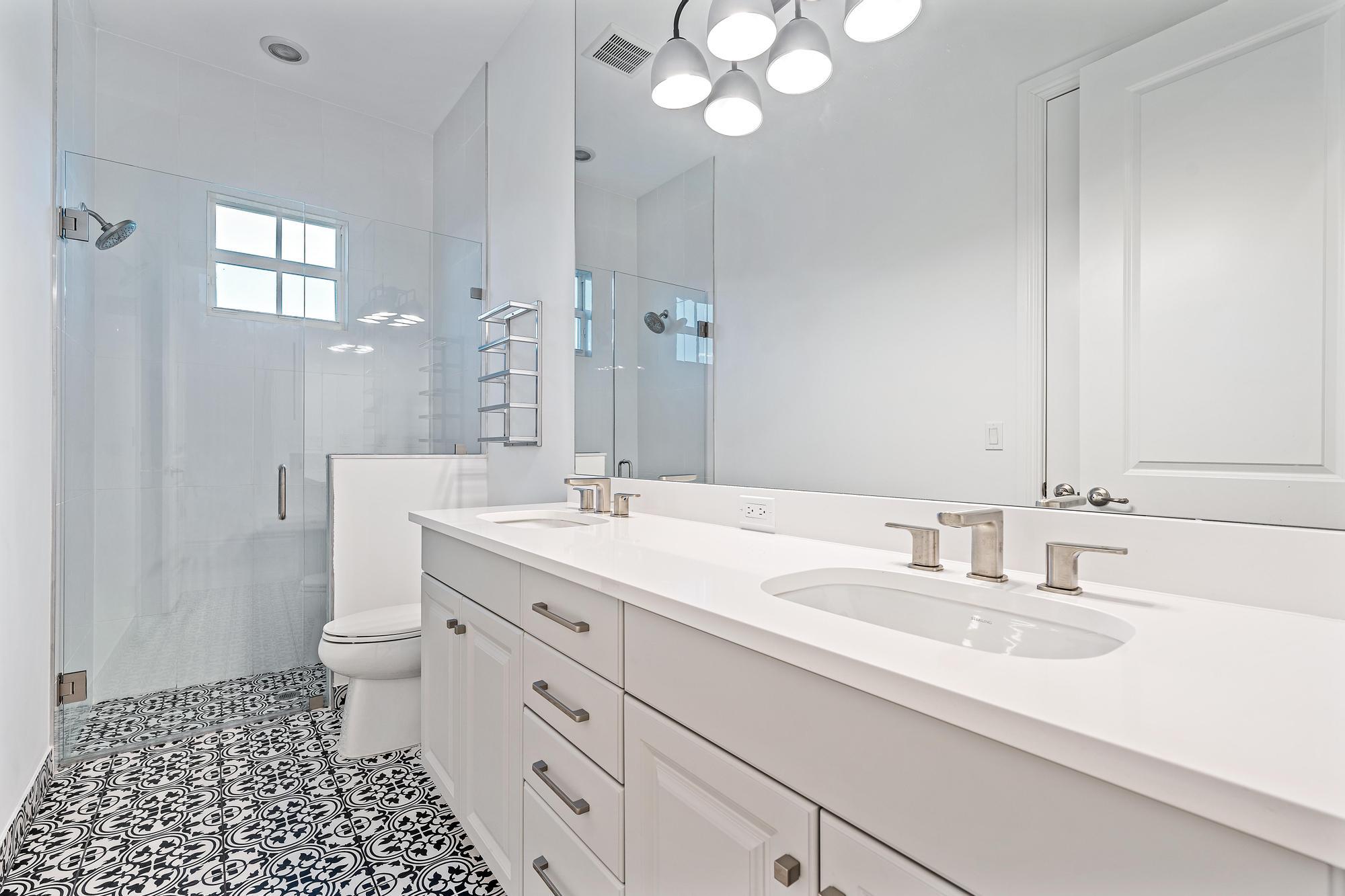 10096 Calabrese Trail Jupiter, FL 33478 - Photo 47 of 58 a bathroom with a double vanity sink mirror and toilet