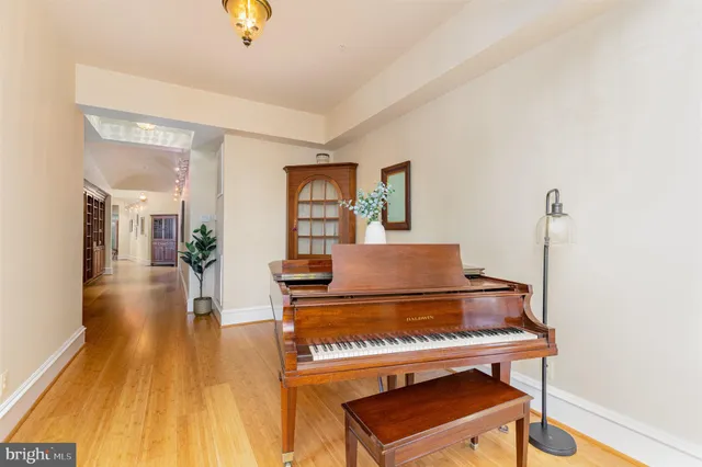 a bedroom with a bed dresser and wooden floor