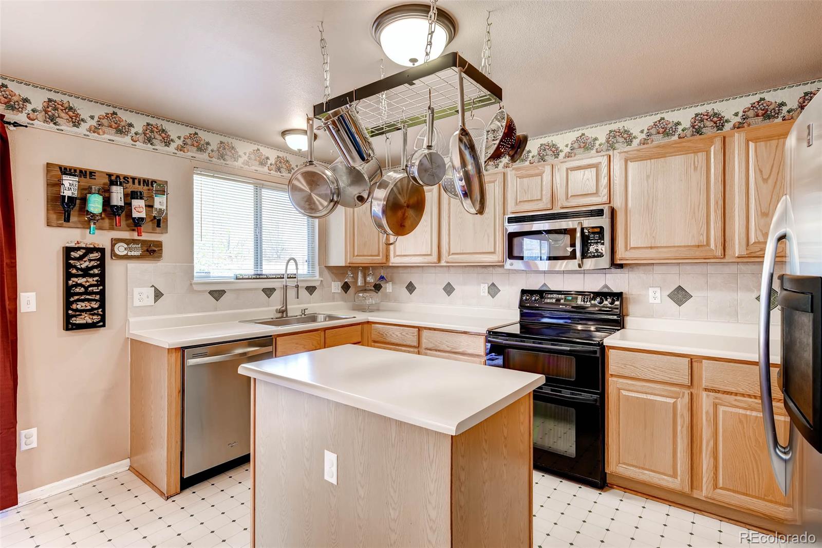 9645 South Castle Ridge Circle Highlands Ranch, CO 80129 - Photo 12 of 28 a kitchen with stainless steel appliances granite countertop a sink stove and refrigerator