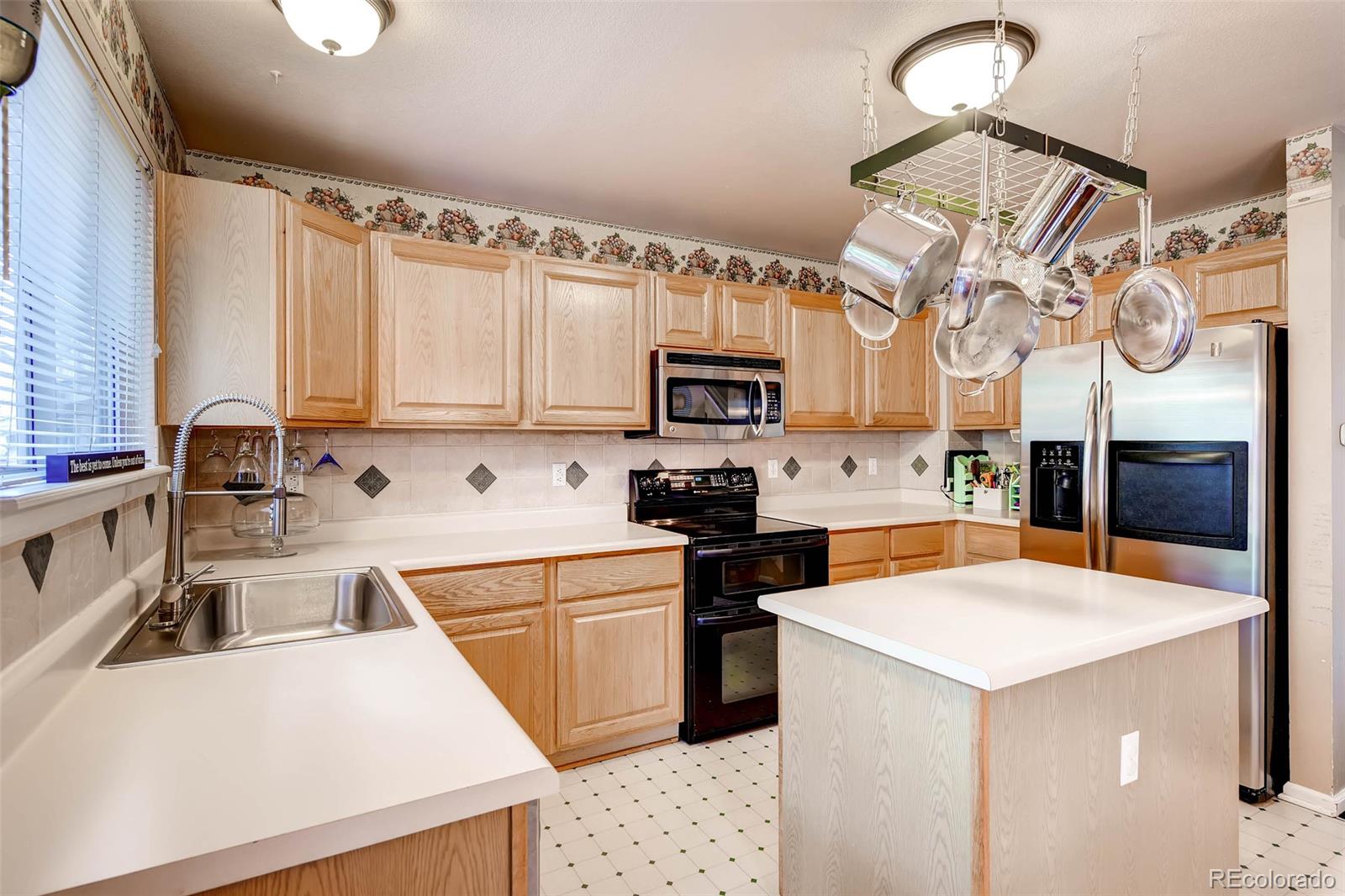9645 South Castle Ridge Circle Highlands Ranch, CO 80129 - Photo 13 of 28 a kitchen with a sink a stove and cabinets