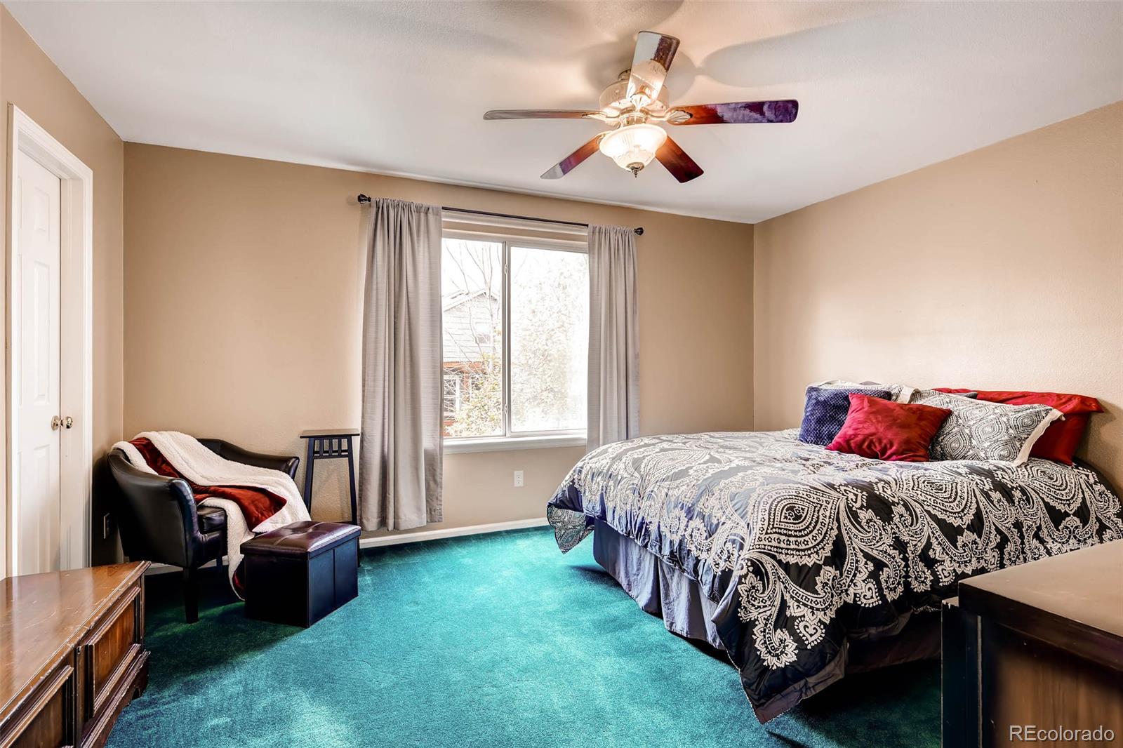9645 South Castle Ridge Circle Highlands Ranch, CO 80129 - Photo 27 of 28 a bedroom with a bed and a chandelier