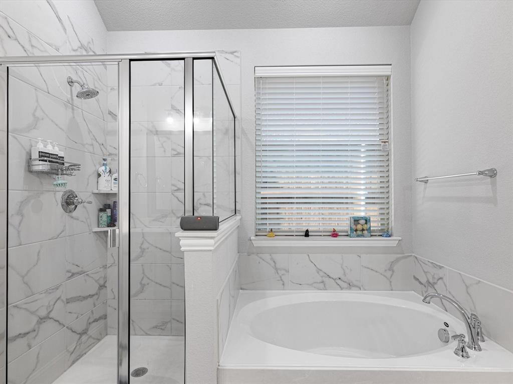 1606 Evening Primrose Drive Mansfield, TX 76063 - Photo 17 of 36 a bathroom with a bathtub and a shower