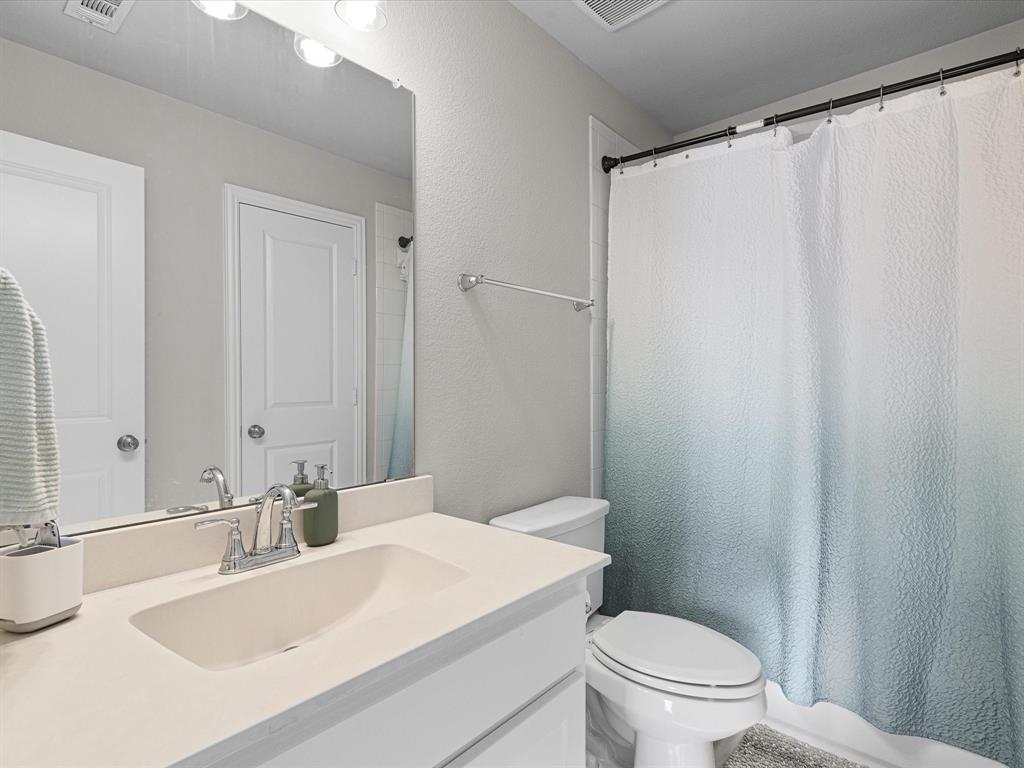 1606 Evening Primrose Drive Mansfield, TX 76063 - Photo 24 of 36 a bathroom with a sink a toilet a mirror and shower curtain