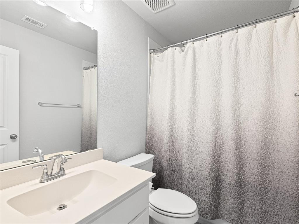 1606 Evening Primrose Drive Mansfield, TX 76063 - Photo 29 of 36 a bathroom with a sink a toilet and shower curtain