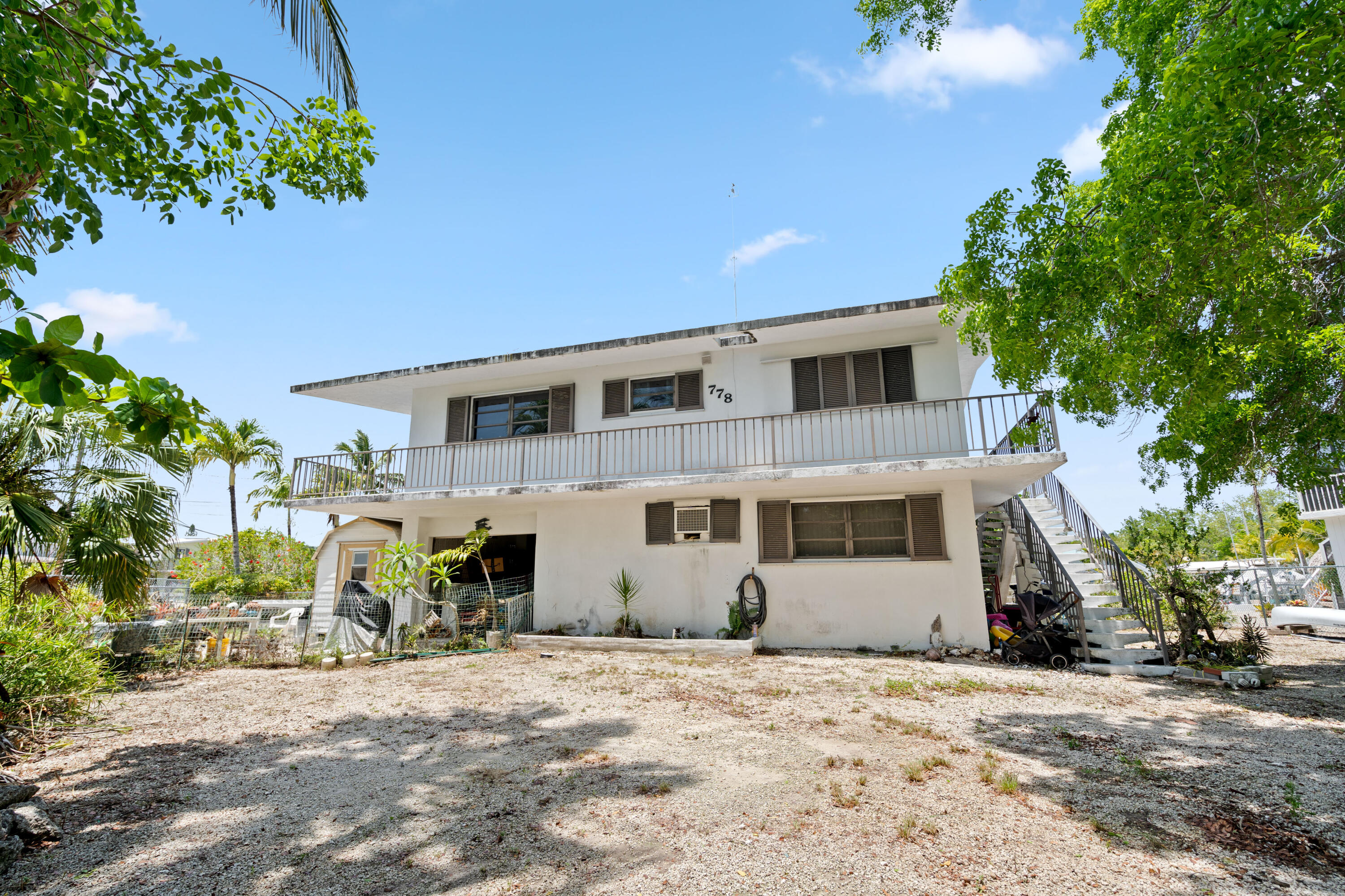 778 Canal Street Key Largo, FL 33037 - Photo 4 of 34 a front view of a house with a yard and garage